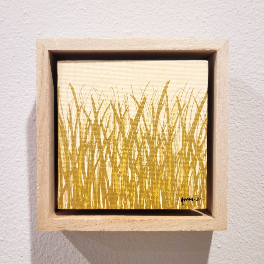 Golden blades of grass set against a cream background on a framed mini-sized canvas panel. Metallic gold colored paint over acrylic. Mounted in floater frame style within a 5" x 5" rustic wooden box frame with mini sawtooth hanger on reverse. The golden grass catches daylight beautifully and is perfectly complemented by the light colored wooden frame.