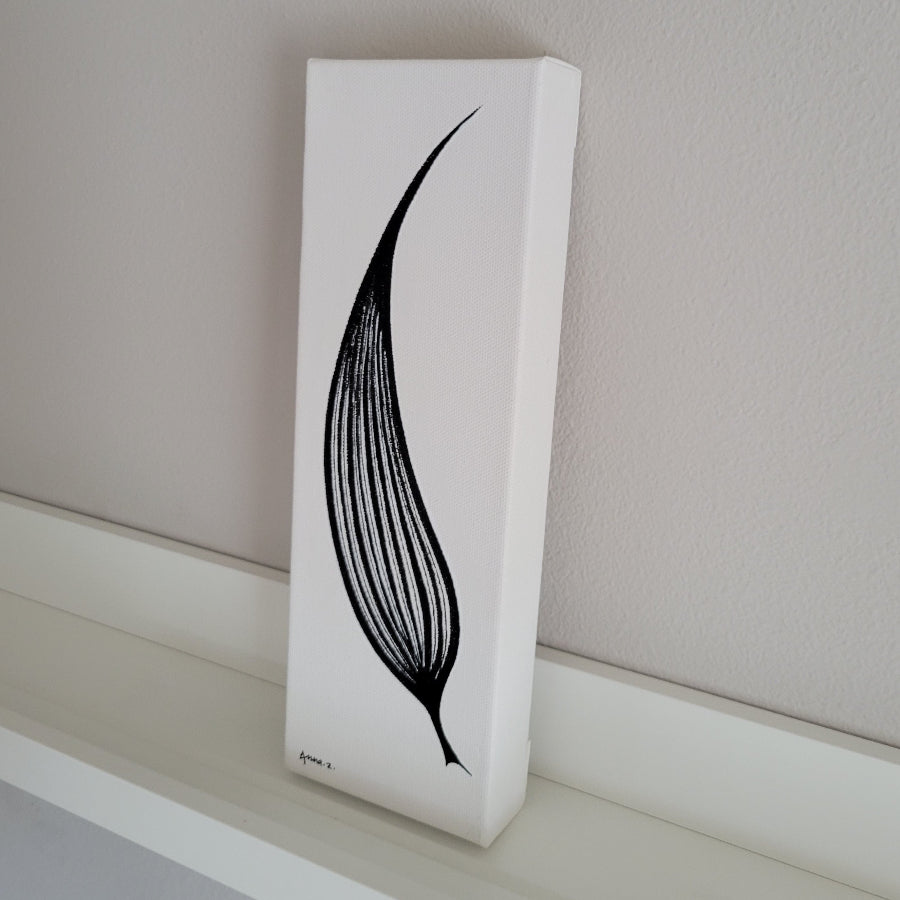 Artwork of a single elongated leaf shaped like a blade. Venation with thick and thin line details brings in a hint of optical illusion. Side view of canvas on picture ledge.