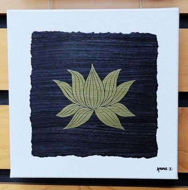 Intricate metallic block print of a lotus blossom embossed on a black background. Deep gold colored embossing on black cardstock and white canvas.