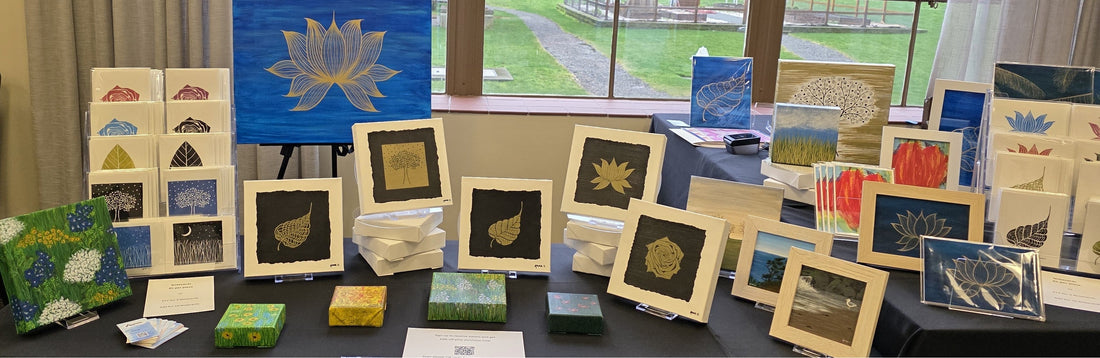 Art Market table display featuring canvas artwork of various sizes and art notecards by Annazach Art