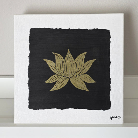 Intricate metallic block print of a lotus blossom embossed on a black background. Deep gold colored embossing on black cardstock and white canvas.