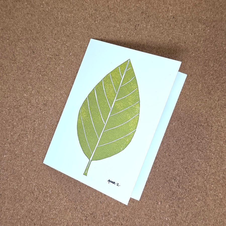 Notecard featuring a digital print reproduction of an original hand-carved block print artwork of a vertical leaf. Green and white artwork.