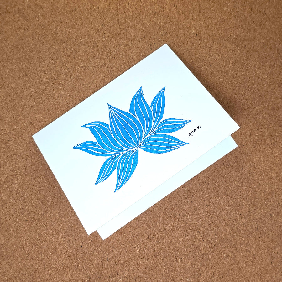 Notecard featuring a digital print reproduction of an original hand-carved block print artwork of a lotus. Blue and white artwork.