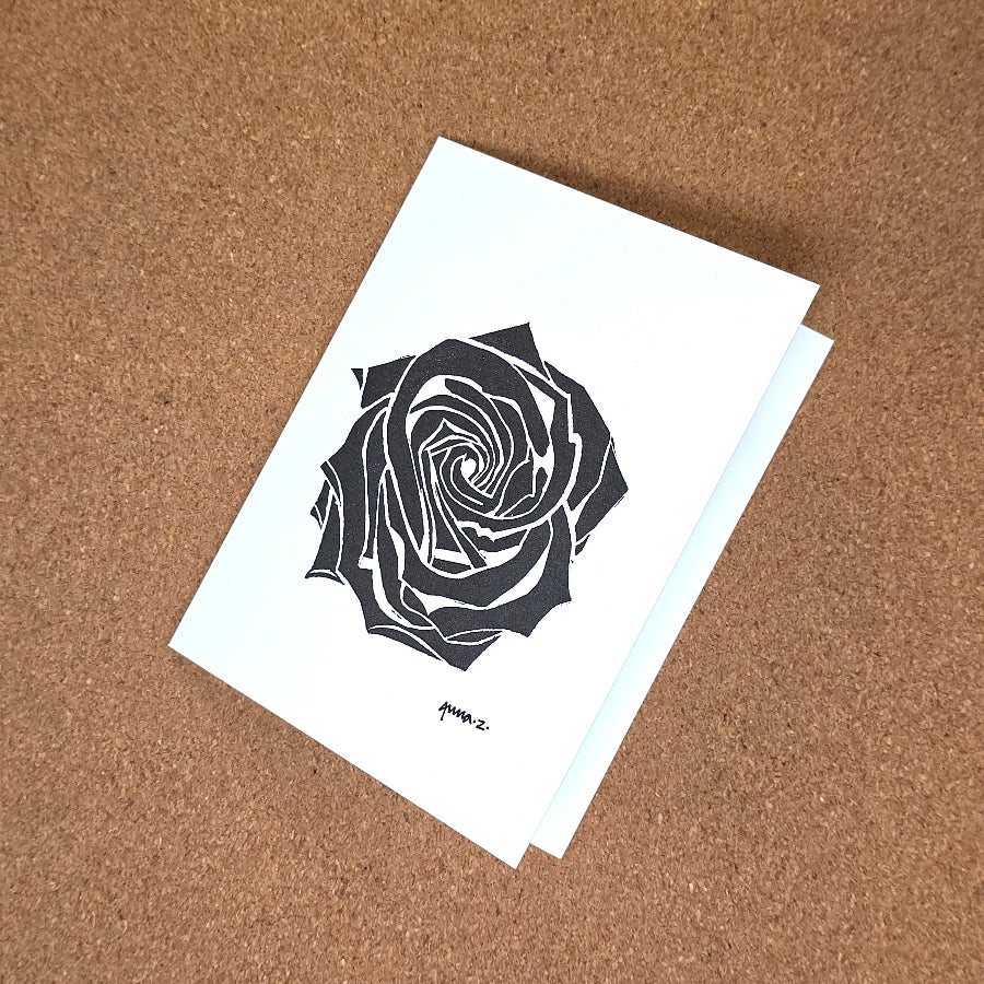 Notecard featuring a digital print reproduction of an original hand-carved block print artwork of a rose in black on a white background.