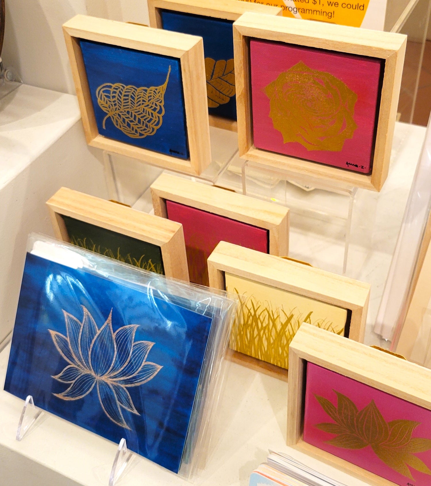 Close-up view of in-store display of botanical themed art prints and small framed canvases