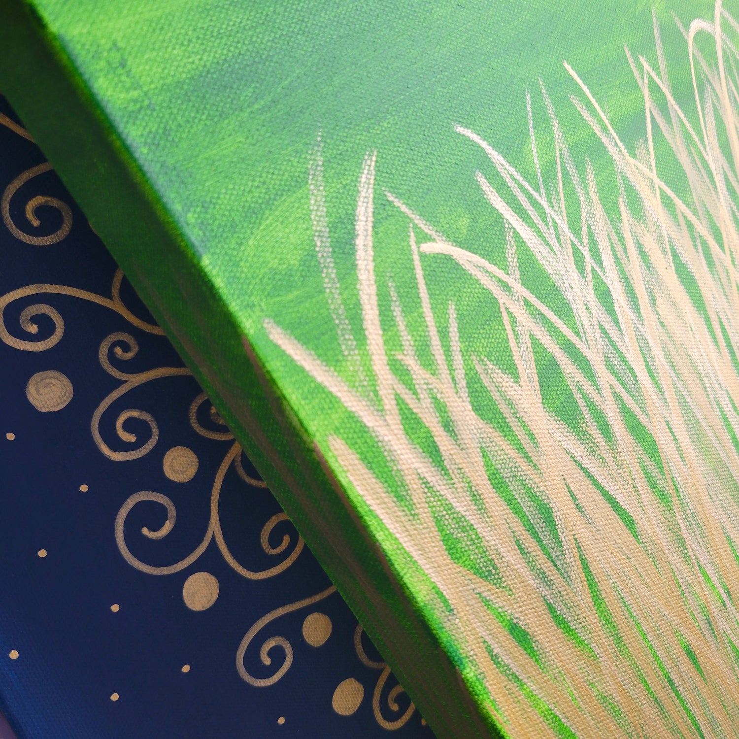 Close up view of two painted canvases to show gold highlights in artwork