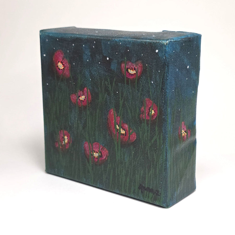 Angled side view of a dreamy mini painting of bright colored poppies take on a magenta hue in cool starlight. Grasses in foreground, and a starry sky with soft hazy clouds in the background. 