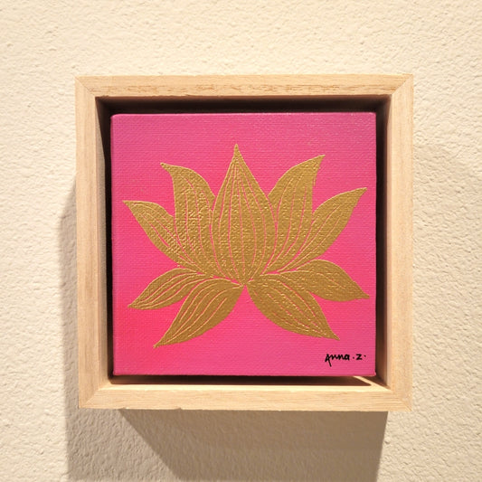 Golden lotus blossom set against a bright pink background on a framed mini-sized canvas panel. Metallic gold colored heat embossing from original carved block design, over an acrylic painted background.  Mounted in floater frame style within a 5" x 5" rustic wooden box frame with mini sawtooth hanger on reverse. The golden petals are perfectly complemented by the light colored wooden frame. 