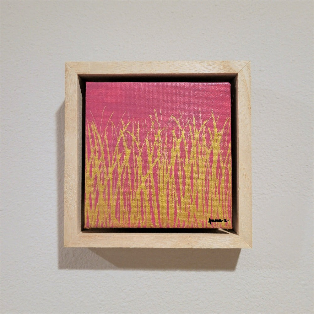 Golden blades of grass set against a bright pink background on a framed mini-sized canvas panel. Metallic gold colored paint over acrylic.  Mounted in floater frame style within a 5" x 5" rustic wooden box frame with mini sawtooth hanger on reverse. The golden grass catches daylight beautifully and is perfectly complemented by the light colored wooden frame. 