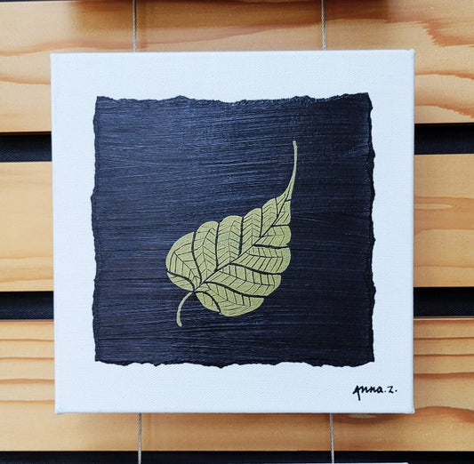 Intricate metallic block print of a banyan leaf embossed on a black background. Deep gold colored embossing on black cardstock and white canvas.