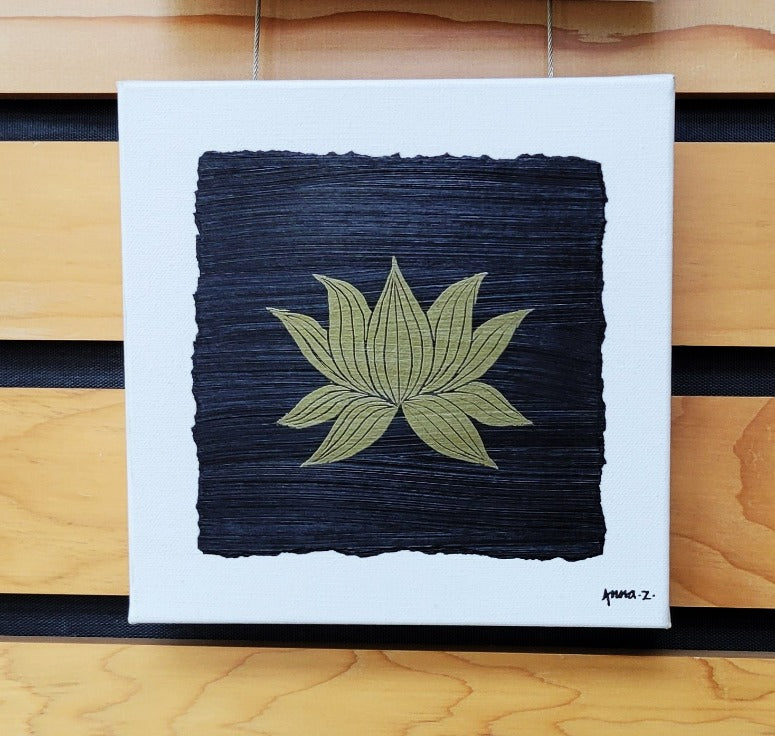 Intricate metallic block print of a lotus blossom embossed on a black background. Deep gold colored embossing on black cardstock and white canvas.